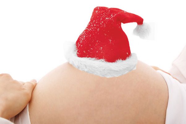 pregnant bump wearing a santa hat for the festive season