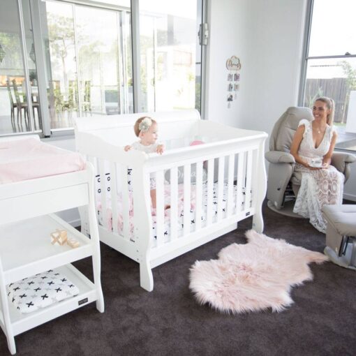 cot in bedroom setting with baby inside