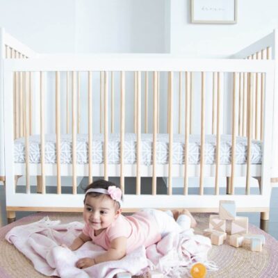 Riya cot in white with baby in front