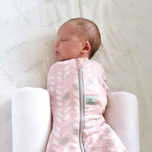 white breathe eze sleep positioner supporting baby wearing a sleeping bag in parents bed