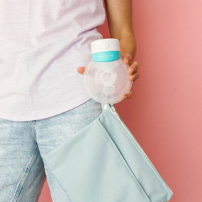 the night owl hands free breast pump held in mums hand at her side